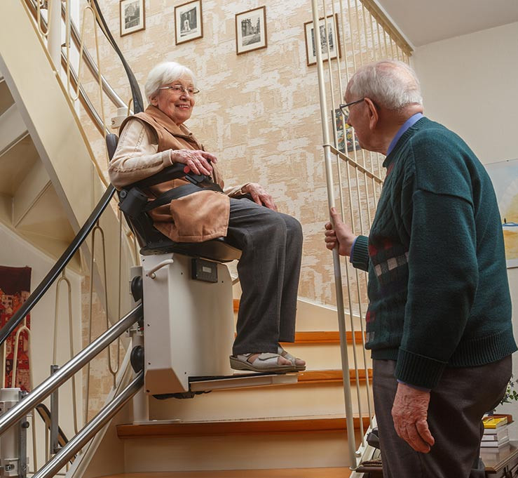 Ein älteres Ehepaar an einem Treppenlift