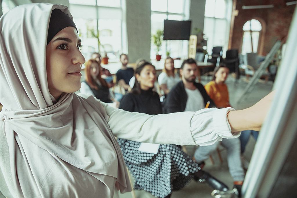 Eine Muslimin hält eine Präsentation vor Publikum