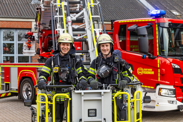 Zwei Feuerwehrleute im Korb eines Feuerwehrwagens