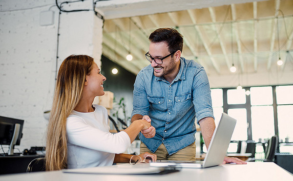 Ein Mann und eine Frau schütteln sich die Hand in einem Büro