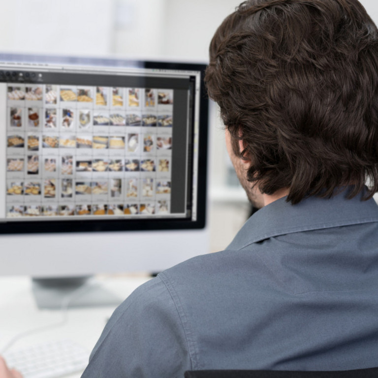 Ein Fotograf bearbeitet Bilder am Computer