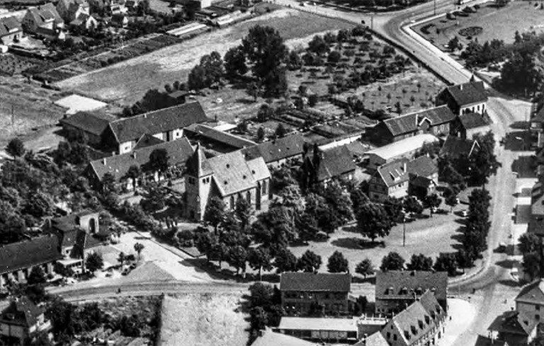 Herringer Markt mit der St. Viktor Kirche im Zentrum, gesehen von Südwesten. Luftaufnahme aus den 1950er-Jahren