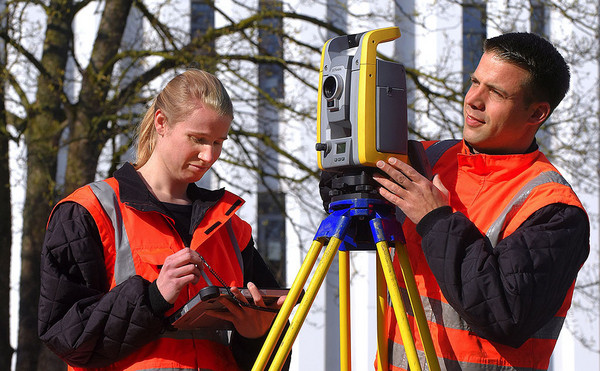 Zwei Vermessungstechniker bei der Arbeit