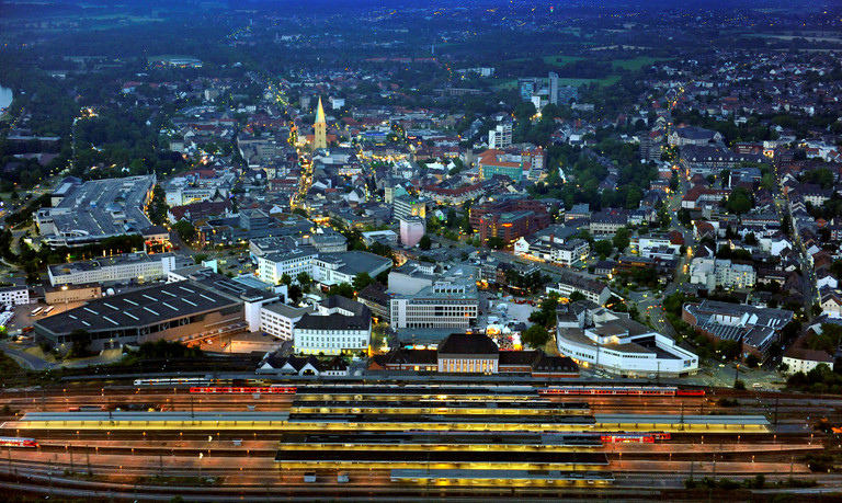 Nachtaufnahme: Luftbild der Innenstadt mit Bahnhof und Gleisen