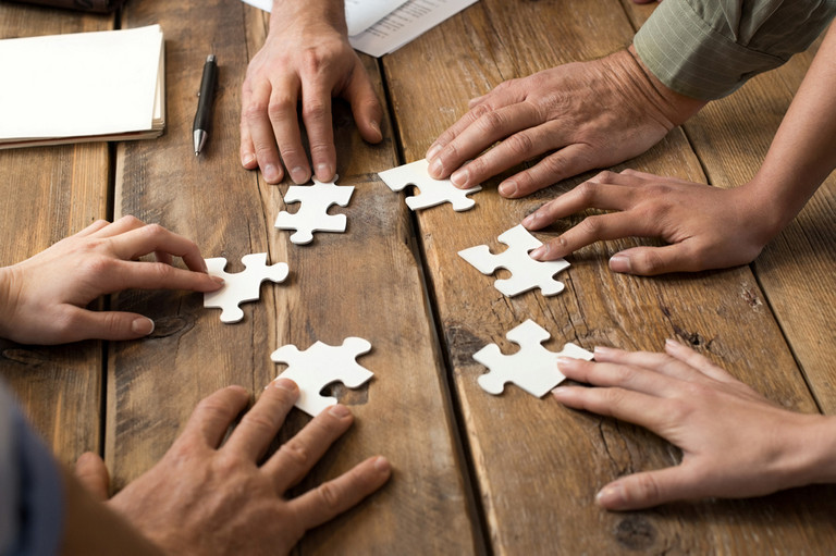 Nahaufnahme Hände von Geschäftsleuten mit Puzzleteilen