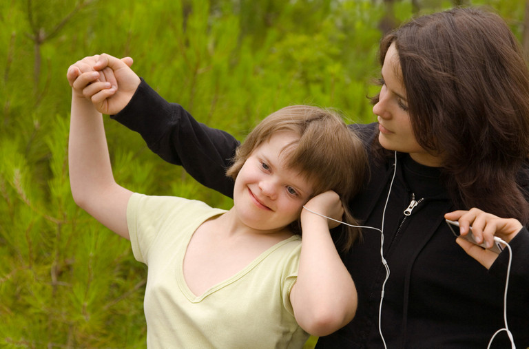 Ein Mädchen mit Down-Syndrom hört Musik über In-Ear-Kopfhörer