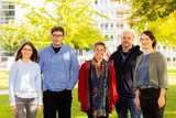 Auf dem Foto sind fünf Personen unter Kastanienbäumen zu sehen: Madeline Frenster steht links, hat dunkle, lange Harre und trägt eine Brille und einen hellblauen Pulli. Tobias Garske hat kurze, dunkle, lockige Harre und einen blauen Kapuzenpulli an. Nicole Denker hat dunkelblonde Harre, trägt einen bunten Schal und eine rote Jacke. Klaus Lindner hat graue Haare, einen Bart und trägt eine dunkle Jacke. Wilma Großmaas hat dunkle Harre, die hochgesteckt sind. Sie trägt einen grünen Blouson und ein blaues Shirt.