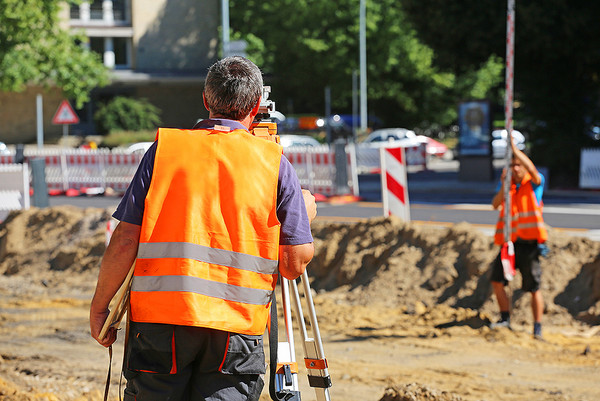 Vermessungstechniker bei der Arbeit auf einer Baustelle