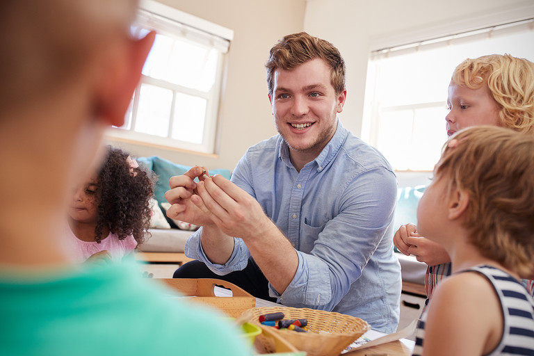 Ein Erzieher spielt mit Kindern in der Kita