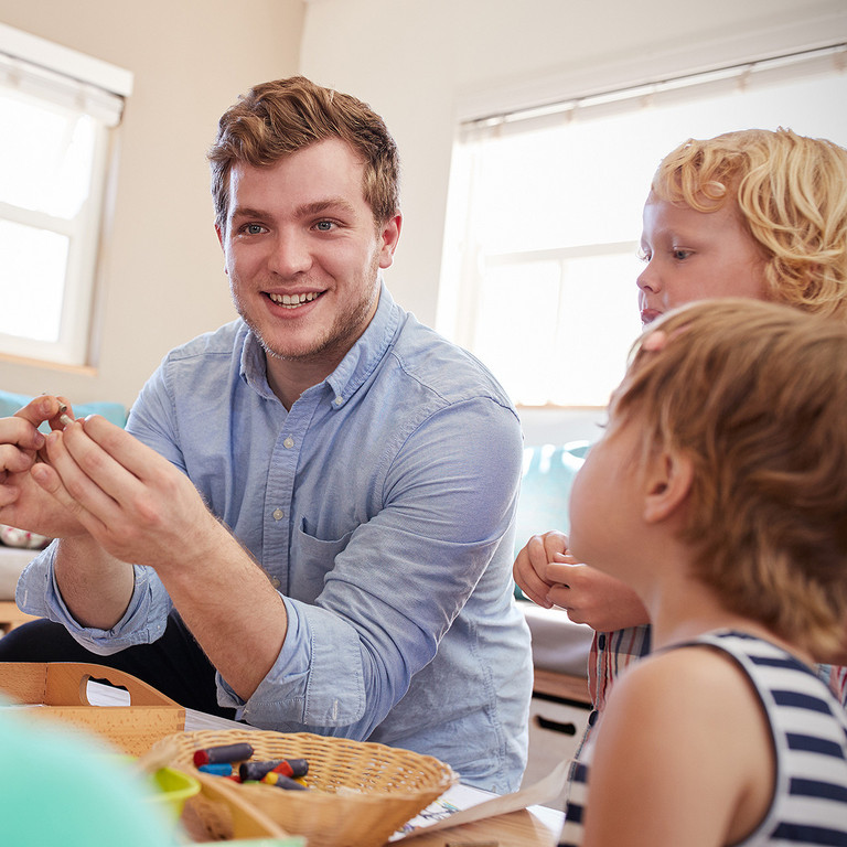 Ein Erzieher spielt mit Kindern in der Kita