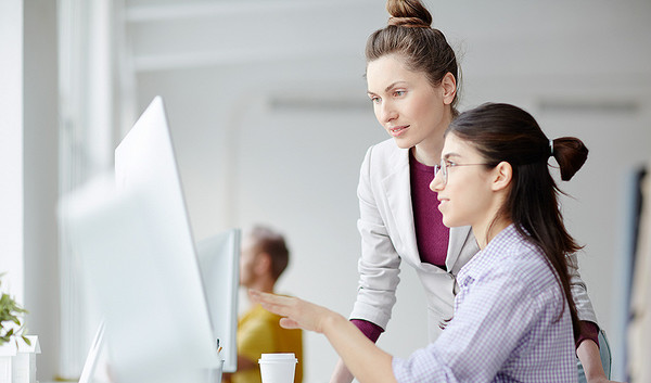 Zwei junge Frauen vor einem Computerbildschirm