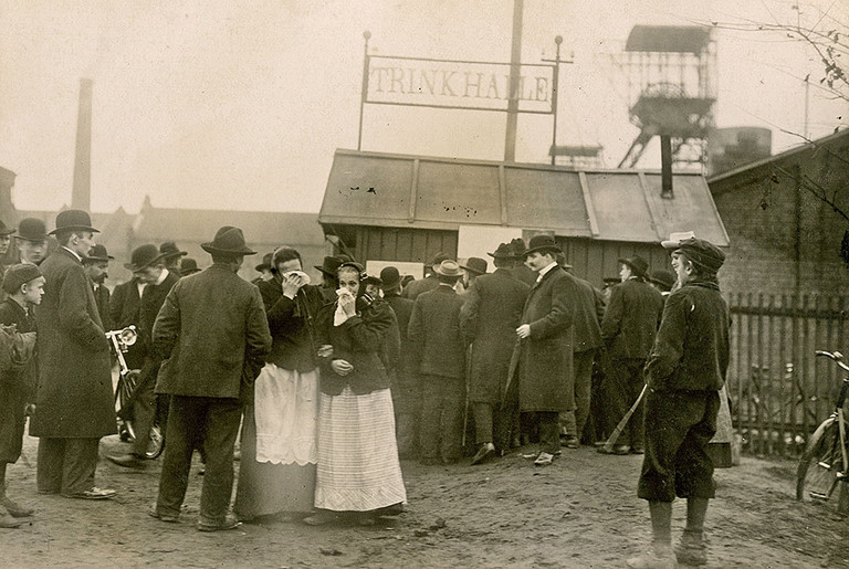 An der Trinkhalle am Zecheneingang der Zeche Radbod werden Listen der Verunglückten ausgehängt, 12. November 1908.