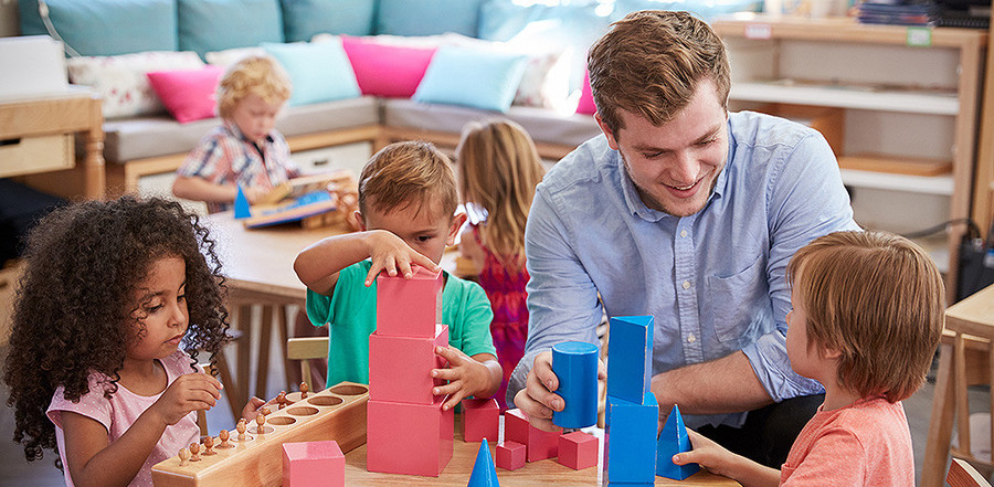 Ein Erzieher spielt mit Kindern in der Kita  