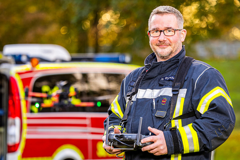 Ein Feuerwehrmann mit dem Steuerungsgerät einer Drohne