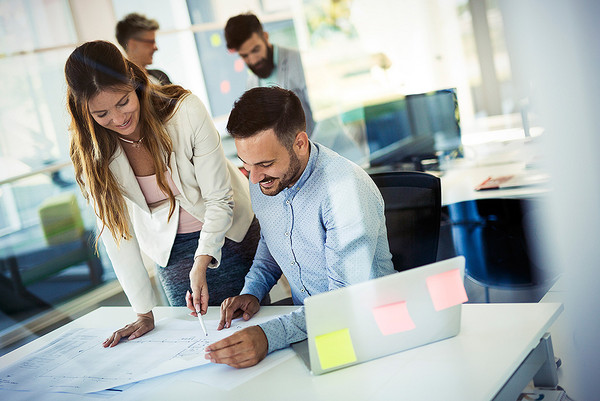 Ein Mann und eine Frau schauen auf einen Plan im Büro