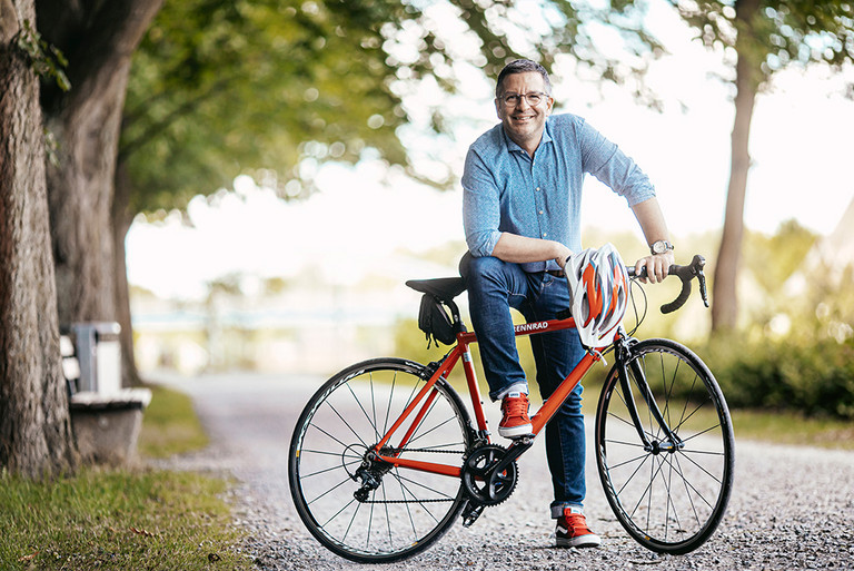 OB Marc Herter mit seinem roten Rennrad auf einem Radweg