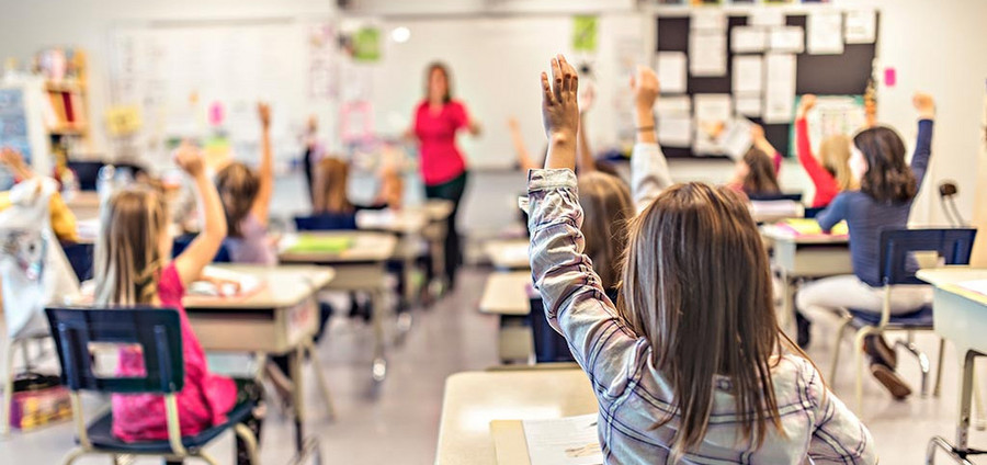 aufzeigende Kinder in einer Unterrichtsklasse