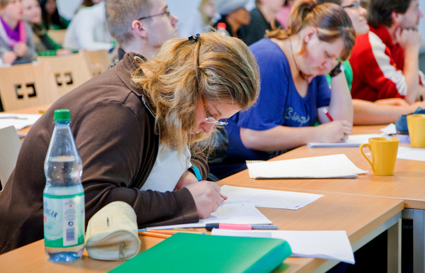 Zwei Studentinnen schreiben in einer Vorlesung