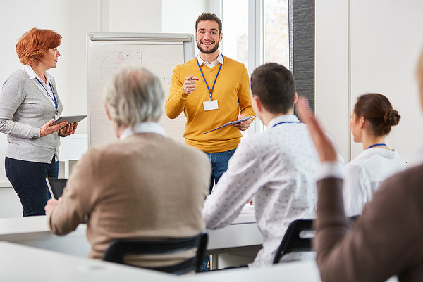 Ein Mann hält ein Seminar vor einer Gruppe von Menschen ab