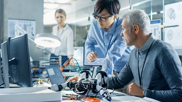 Zwei Wissenschaftler untersuchen einen Roboter