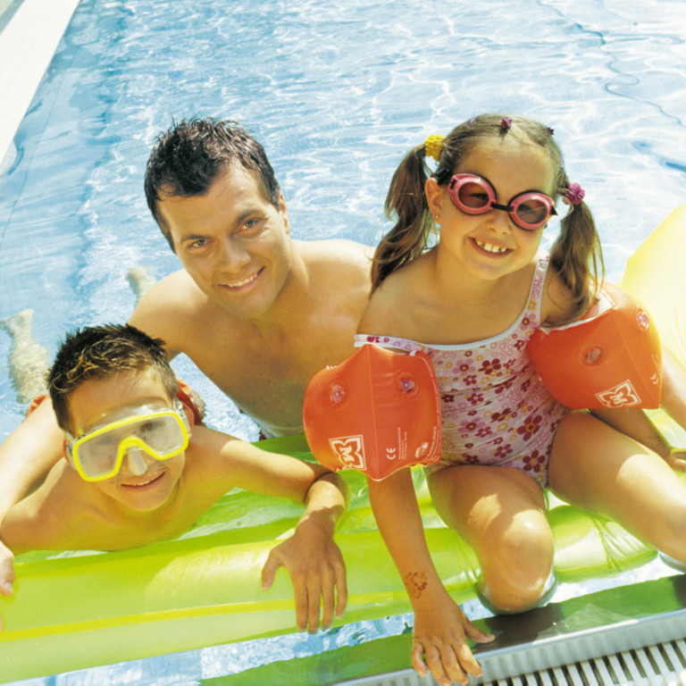 Vater mit zwei Kindern im Schwimmbad