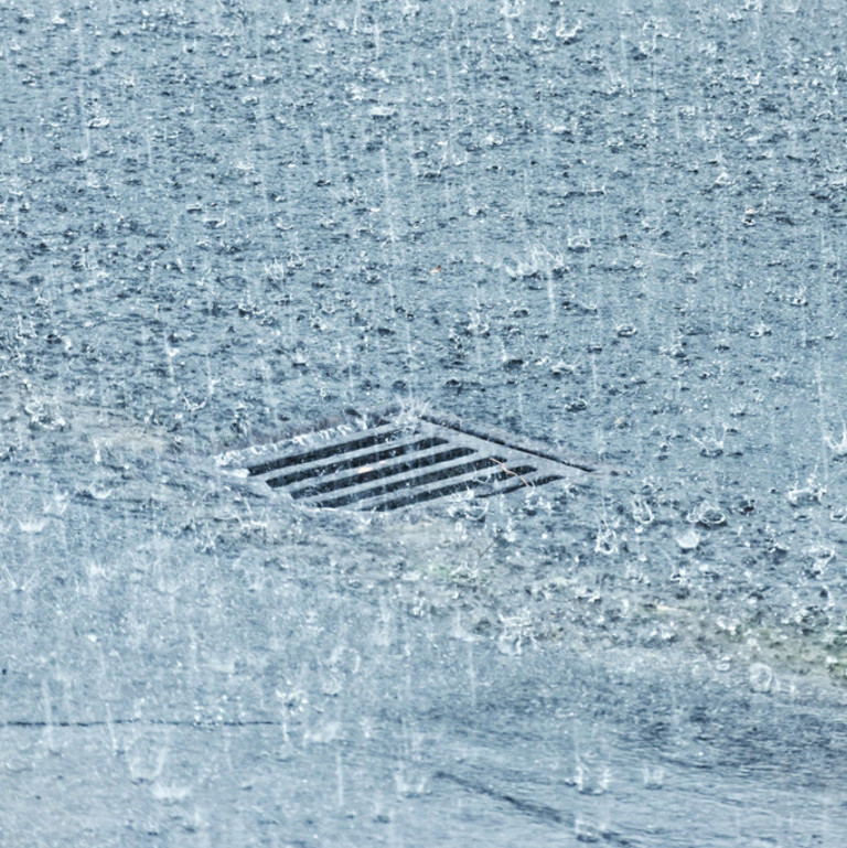 Starker Regen prasselt auf eine Straße nieder