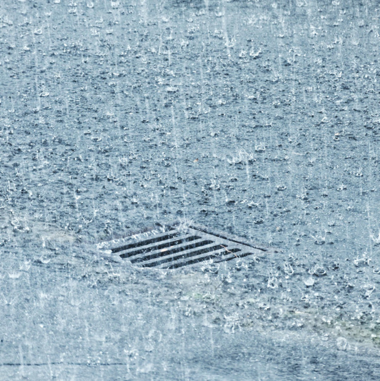 Starker Regen prasselt auf eine Straße nieder