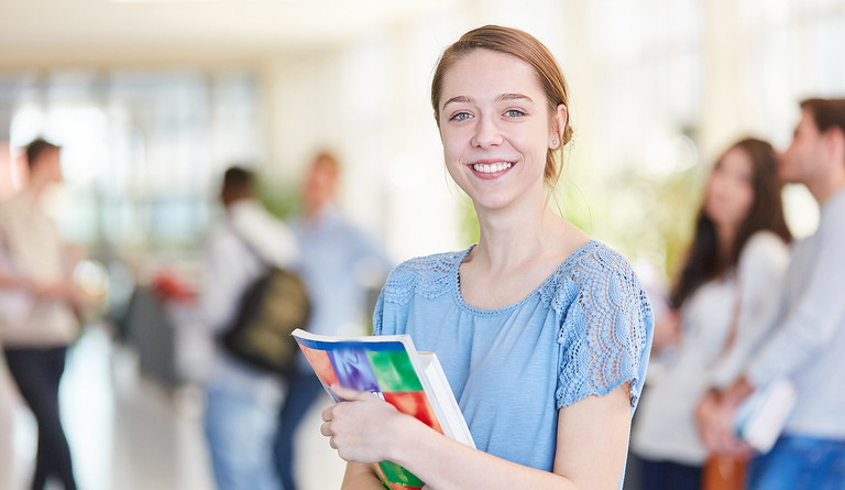 Eine junge Frau mit Büchern im Arm