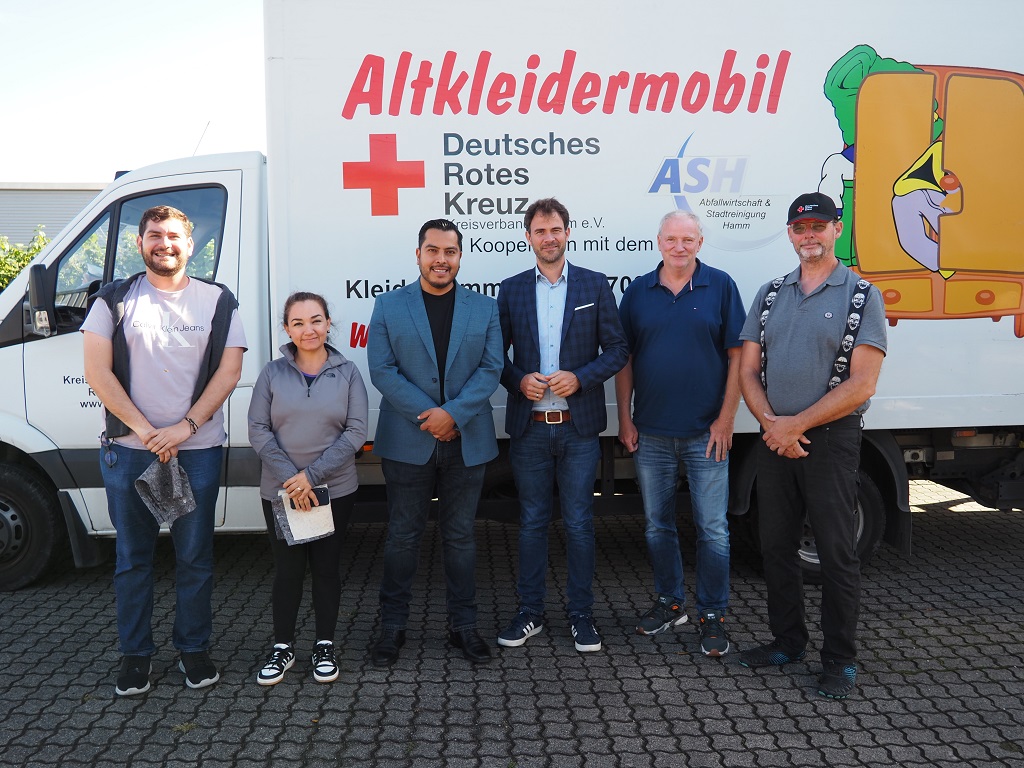 Das Bild zeigt v.l.n.r.: Jose Pablo Moreno, Eunice Murúa Figueroa, Luis Arnulfo Vargas Montes (alle Teil der Delegation aus Mazatlán), Robert Reminghorst (Betriebsleiter des Abfallwirtschafts- und Stadtreinigungsbetriebs Hamm), Uwe Sauerland (Stadt Hamm, Leiter des Büros des Rates) und Andreas Hölscher (Deutsches Rotes Kreuz Kreisverband Hamm, Leiter der Zentralen Dienste) bei der Besichtigung des DRK vor dem Altkleidermobil des DRK.