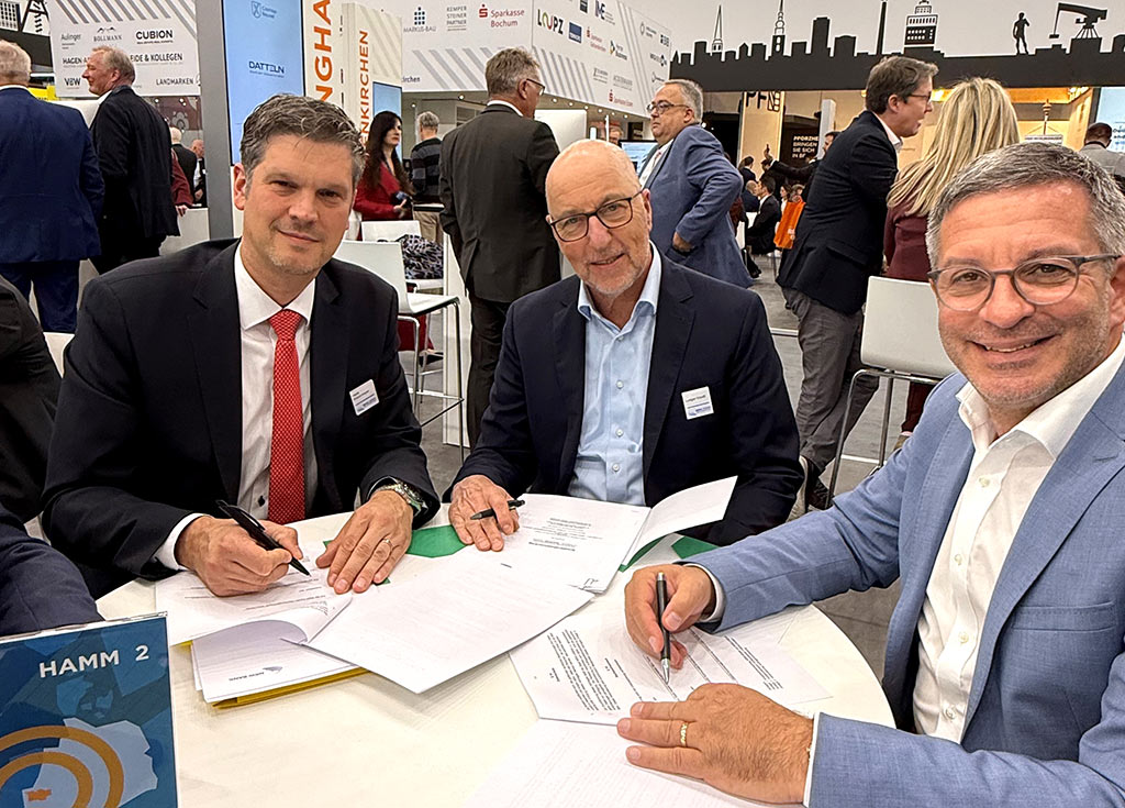 Die Unterzeichner des Entwicklungsträgervertrages auf der EXPO Real in München (von links): Henk Brockmeyer, Ludger Kloidt (beide Geschäftsführer NRW.URBAN), Oberbürgermeister Marc Herter  Drei Männer unterzeichnen einen Vertrag auf einer Immobilien-Messe